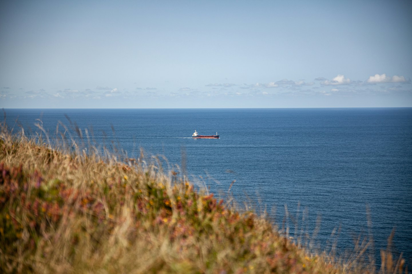 A large cargo ship sails across the open ocean.
